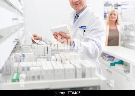 Il farmacista prescrizione di riempimento in farmacia Foto Stock