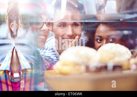 Amici puntando al dessert in caso di visualizzazione al cafe Foto Stock