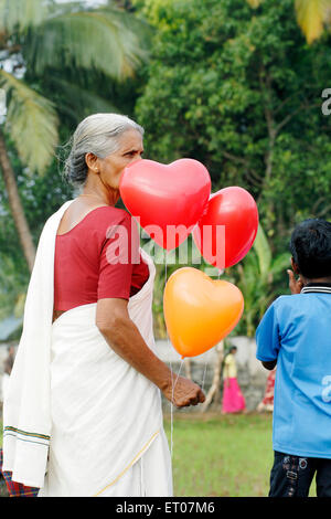 Donna con palloncini a forma di cuore, kerala, India, asia Foto Stock