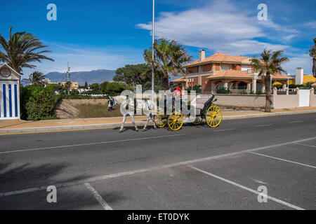 Un carro trainato da cavalli passeggiando lungo la promenade Foto Stock