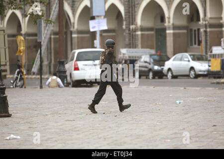 La sicurezza nazionale guardie commando NSG in esecuzione gun militanti di battaglia Taj Mahal Hotel attacco terroristico Deccan Mujahidee Bombay Foto Stock