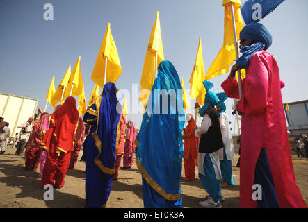 Giovane sikh costumi tradizionali bandiere di contenimento ; eventi culturali ; celebrazioni consacrazione perpetua Guru Granth Sahib ; Nanded Foto Stock