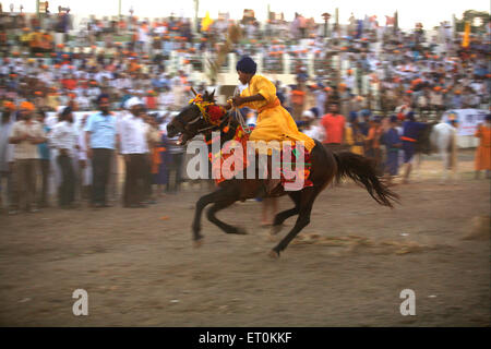 Nihang guerriero Sikh eseguono acrobazie ; evento onsecration di perpetua Guru del Guru sikh Granth a Khalsa sportivo Nanded Foto Stock