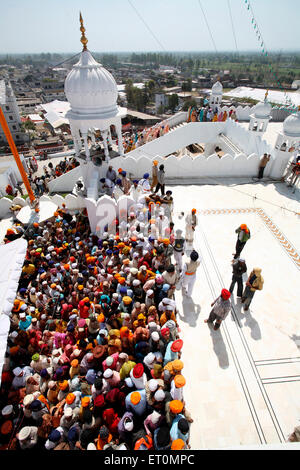 Folle di devoti in code durante il festival di Hola Mohalla a Anandpur Sahib Gurudwara nel distretto di Rupnagar ; Punjab ; India Foto Stock