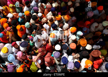 Folle di devoti in code durante il festival di Hola Mohalla a Anandpur Sahib Gurudwara nel distretto di Rupnagar Punjab India Foto Stock