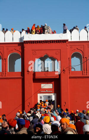 I devoti all'entrata di Anandgarh forti durante la celebrazione della Hola Mohalla a Anandpur Sahib Rupnagar Foto Stock