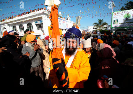 La religione sikh devoto che trasportano nishansahib santo bandiera durante la processione di Hola Mohalla di Anandpur sahib in Rupnagar Foto Stock