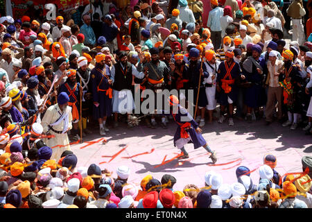 Nihang o guerrieri Sikh eseguono acrobazie con arma in durante la hola Mohalla celebrazioni a Anandpur sahib in Rupnagar Foto Stock