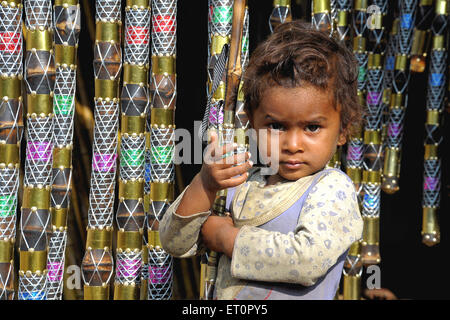 Bambino che detiene artigianato di bambù ; fiera Pushkar ; Rajasthan ; India Foto Stock