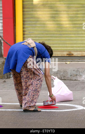 Donna che fa rangoli sulla strada che celebra Gudi Pasda, indù nuovo anno, Thane, Maharashtra, India Foto Stock