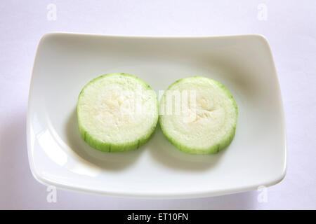 Vegetali verdi ; fettine rotonde di ghiya nanuan pompion superriduttore tipo di zucca in rettangolo piastra su sfondo grigio Foto Stock