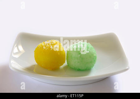 Mithai ; nariyal colorati ka laddoos nel rettangolo piastra su sfondo bianco Foto Stock