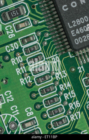 Macro-foto dei componenti del circuito stampato su una scheda madre del PC. Cablaggio all'interno del computer, primo piano del circuito, dettaglio di una scheda di circuito, punti collegati. Foto Stock