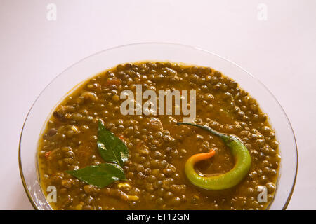 Indian masoor dal red grammo zuppa di lenticchie guarnite con foglie di curry e peperoncino in vaso di vetro su sfondo bianco 21 Aprile 2010 Foto Stock