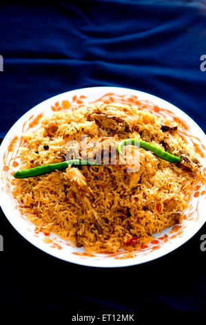 Biryani di pollo con peperoncini verdi nella piastra con sfondo blu Foto Stock