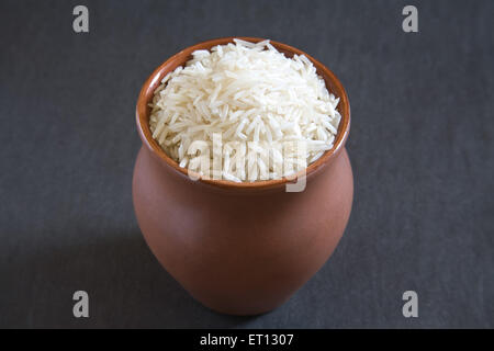 ; I grani di riso basmati oryza sativa in pentola di terra su sfondo grigio 20 Maggio 2010 Foto Stock