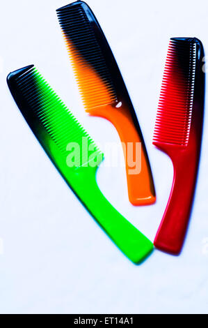 pettini verdi arancioni rossi su sfondo bianco Foto Stock