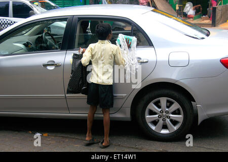 Ragazzo la vendita per i proprietari di auto sulle strade di Mumbai India Foto Stock