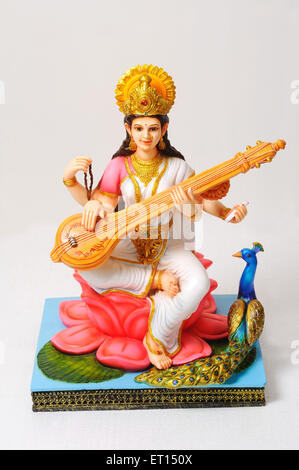 Dea saraswati giocando veena seduto su lotus con peacock statua in argilla Foto Stock