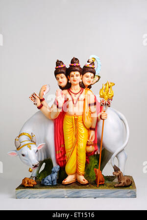 Tre faccia Dio Shri Gurudev Datta Dattatreya Dattaguru con mucca e cani scultura statua di argilla Signore Brahma Vishnu e Shiva in un'unica forma India Foto Stock