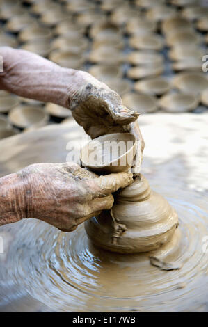 Potter che fa diya di creta sulla ruota dei vasai Foto Stock