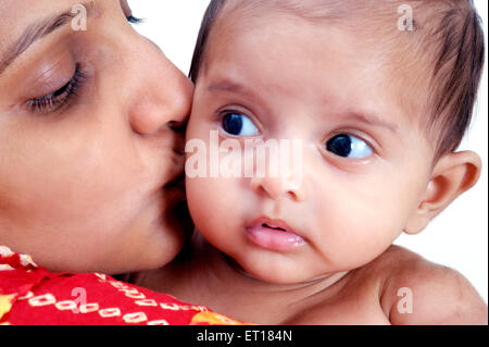Madre indiana kissing baby bambino guance sfondo bianco - signor#736k&la - rmm 179691 Foto Stock