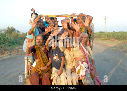 Le donne indiane e i bambini che viaggiano in rickshaw agitando mani Amreli Gujarat India Signor#364 Foto Stock