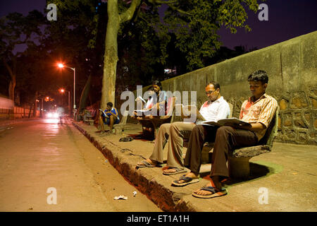 Studenti che studiano sotto la luce di strada sul marciapiede, Abhiyas Galli, Bombay, Mumbai, Maharashtra, India, Asia, Asia, India Foto Stock