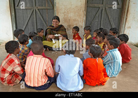 Insegnante di scuola rurale con bambini iniziativa sociale avviata da ONG Chinmaya Organizzazione di sviluppo rurale India Asia Foto Stock