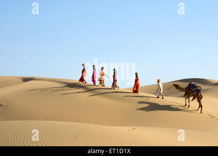 Uomo e donna con il camel camminando sul deserto Jaisalmer Rajasthan India - signor#704 - shi 176993 Foto Stock