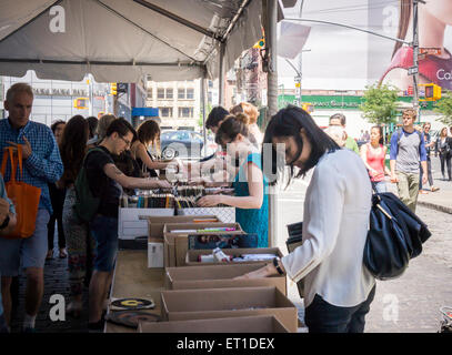 Gli amanti dello shopping ricerca di occasioni tra il caos delle opere di alloggiamento street fair su Crosby Streetin New York quartiere di Soho, domenica 7 giugno, 2015. Opere di alloggiamento aiuti le persone colpite dal virus HIV/AIDS ha la vendita annuale in cui migliaia di libri, film, le registrazioni e i capi di abbigliamento sono venduti per un dollaro o meno, attirando migliaia di persone. (© Richard B. Levine) Foto Stock