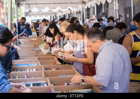 Gli amanti dello shopping ricerca di occasioni tra il caos delle opere di alloggiamento street fair su Crosby Streetin New York quartiere di Soho, domenica 7 giugno, 2015. Opere di alloggiamento aiuti le persone colpite dal virus HIV/AIDS ha la vendita annuale in cui migliaia di libri, film, le registrazioni e i capi di abbigliamento sono venduti per un dollaro o meno, attirando migliaia di persone. (© Richard B. Levine) Foto Stock