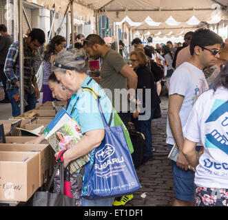 Gli amanti dello shopping ricerca di occasioni tra il caos delle opere di alloggiamento street fair su Crosby Streetin New York quartiere di Soho, domenica 7 giugno, 2015. Opere di alloggiamento aiuti le persone colpite dal virus HIV/AIDS ha la vendita annuale in cui migliaia di libri, film, le registrazioni e i capi di abbigliamento sono venduti per un dollaro o meno, attirando migliaia di persone. (© Richard B. Levine) Foto Stock