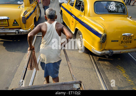 Man mano tirando il rickshaw sulla strada Kolkata West Bengal India Asia Foto Stock