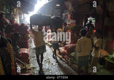 Uomo che porta verdura sacco mercato in Kolkata West Bengal India Asia Foto Stock