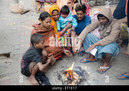I popoli riscaldando le mani sul fuoco Kolkata West Bengal India Asia Foto Stock