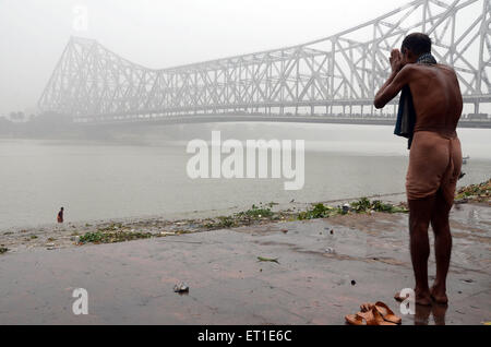 Uomo che prega Fiume Hooghly Makar Sankranti Kolkata West Bengal India Asia Foto Stock