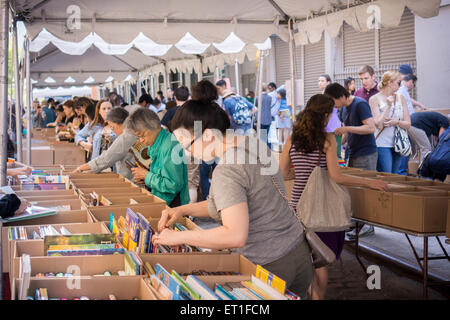 Gli amanti dello shopping ricerca di occasioni tra il caos delle opere di alloggiamento street fair su Crosby Streetin New York quartiere di Soho, domenica 7 giugno, 2015. Opere di alloggiamento aiuti le persone colpite dal virus HIV/AIDS ha la vendita annuale in cui migliaia di libri, film, le registrazioni e i capi di abbigliamento sono venduti per un dollaro o meno, attirando migliaia di persone. (© Richard B. Levine) Foto Stock