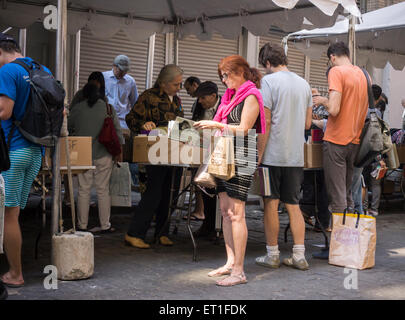 Gli amanti dello shopping ricerca di occasioni tra il caos delle opere di alloggiamento street fair su Crosby Streetin New York quartiere di Soho, domenica 7 giugno, 2015. Opere di alloggiamento aiuti le persone colpite dal virus HIV/AIDS ha la vendita annuale in cui migliaia di libri, film, le registrazioni e i capi di abbigliamento sono venduti per un dollaro o meno, attirando migliaia di persone. (© Richard B. Levine) Foto Stock