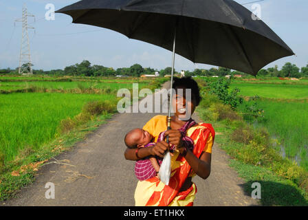 Ho tribù donna che porta il bambino nel sacchetto di panno legata ; Chakradharpur ; Jharkhand ; India n. MR Foto Stock