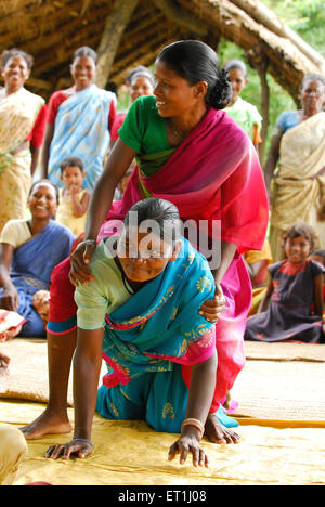 Ho tribù donne giocando piggybacking e la condivisione di informazioni mediche ; Chakradharpur ; Jharkhand ; India n. MR Foto Stock