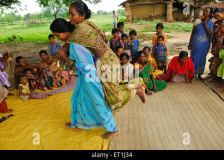 Ho tribù donne giocando piggybacking e la condivisione di informazioni mediche ; Chakradharpur ; Jharkhand ; India n. MR Foto Stock