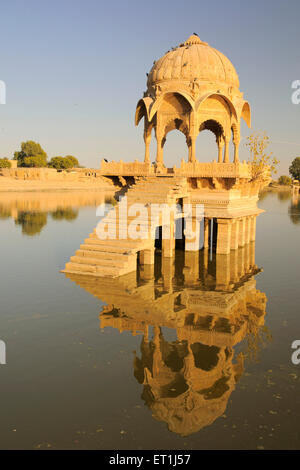 Il cenotafio chiamato chhatri riflesso nell'acqua costruito nel centro di Gadsisar o Gadisar lake ; Jaisalmer ; Rajasthan ; India Foto Stock