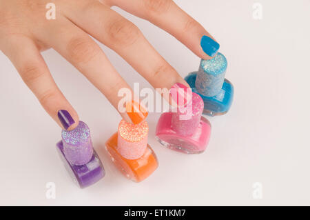 dita con diversi colori bottiglie smalto per unghie Foto Stock