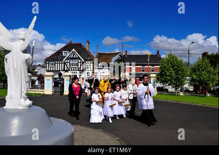 I sacerdoti cattolici conducono una processione attraverso Buncrana nella Contea di Donegal, Irlanda in occasione della festa del Corpus Domini. Foto Stock