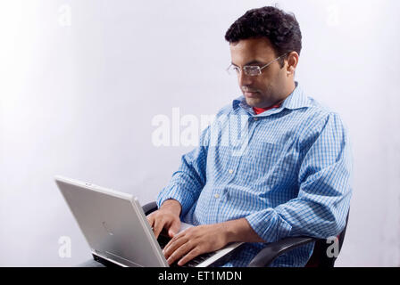 Giovane uomo usando il suo computer portatile ; India Signor#556 Foto Stock