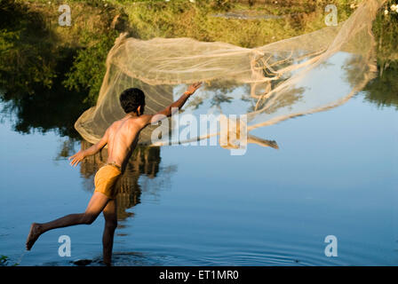 pescatore gettando la rete di pesca nel fiume Krishna a Mahuli ; Sangameshwar vicino Satara città ; Maharashtra ; India Foto Stock