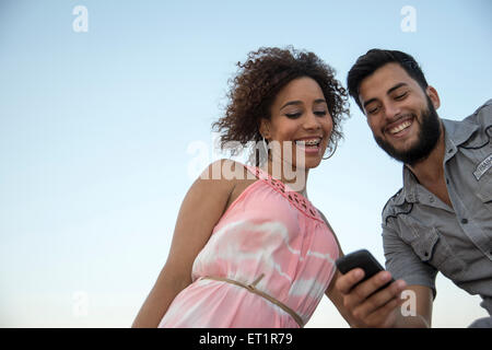 Coppia giovane con un telefono cellulare Foto Stock