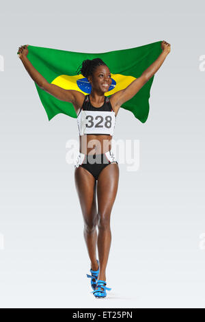 Atleta femminile tenendo una bandiera brasiliana Foto Stock