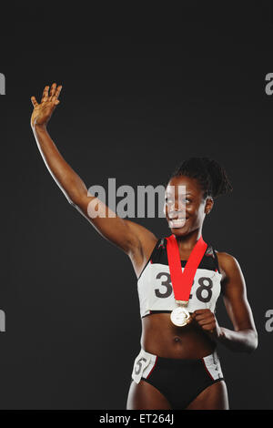 Femmina africana atleta che indossa la medaglia e celebrando Foto Stock